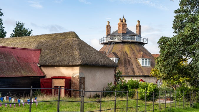 View of the house at A la Ronde, Devon, beyond the thatched barn.